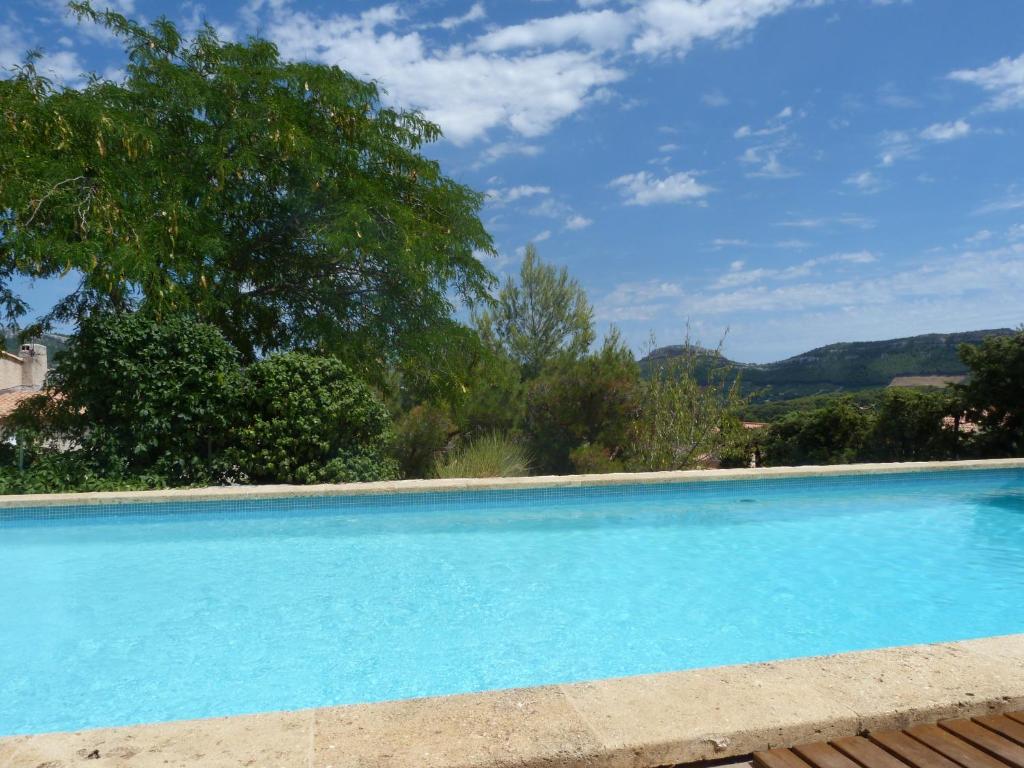 a large blue swimming pool with trees in the background at Chez nous Cassis in Cassis