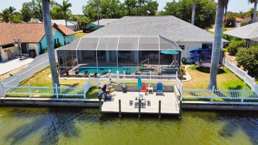 una casa con un barco en el agua en Luxury Waterfront Vacation Home with Dock and free heated Pool, en Cabo Coral