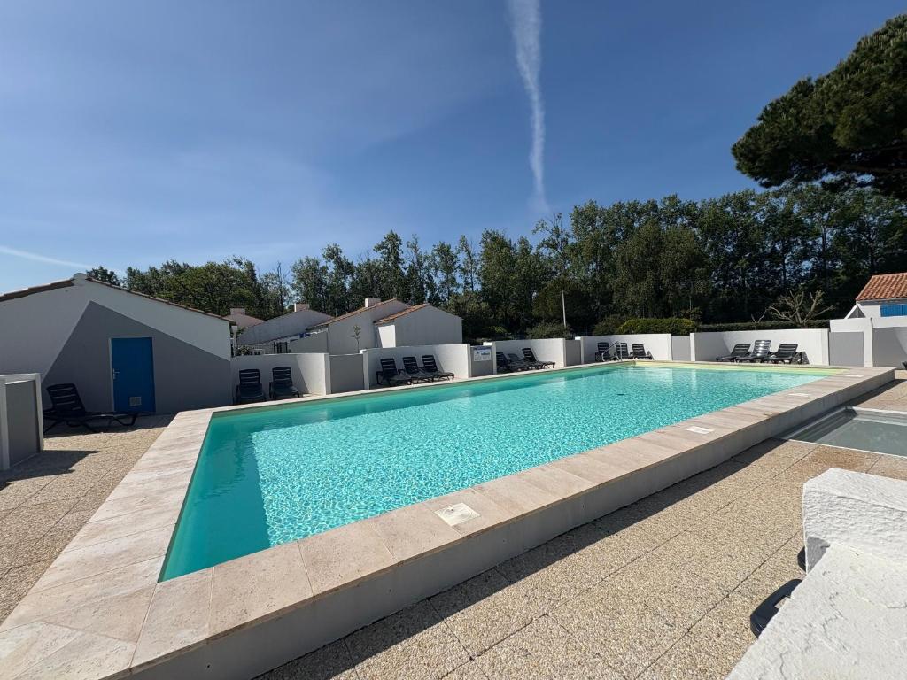 une piscine dans l'arrière-cour d'une maison dans l'établissement Maisonnette studio mezzanine avec piscine chauffée, proche plage et commerces - St Jean de Monts - FR-1-323-269, à Saint-Jean-de-Monts