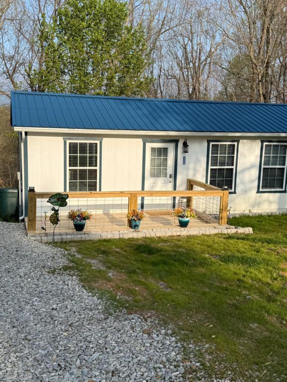 a small white house with a blue roof at 2 Bedroom home near Mammoth Cave NP in Mammoth Cave