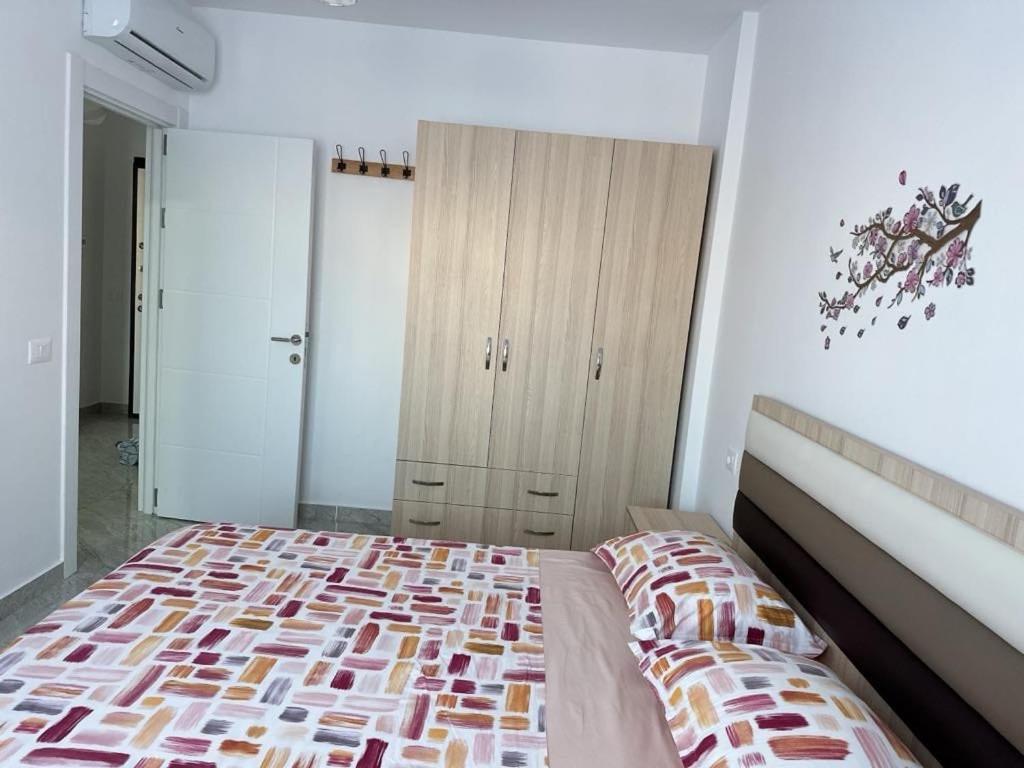 Un dormitorio con una cama y una cómoda. en Jimmys Apartment, en Lezhë