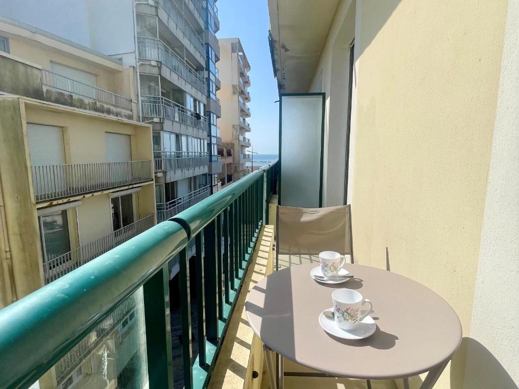 - un balcon avec deux tasses de café sur une table dans l'établissement T2 Confortable, 2 min de la Plage, Aperçu Mer, Quartier Arago - FR-1-92-572, à Les Sables-dʼOlonne