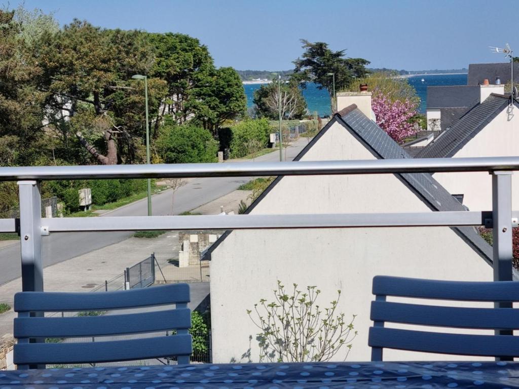 d'une table et de chaises sur un balcon avec vue sur la rue. dans l'établissement Appartement T3 près plage, parking, animaux admis, 4 personnes - FR-1-775-23, à Sarzeau