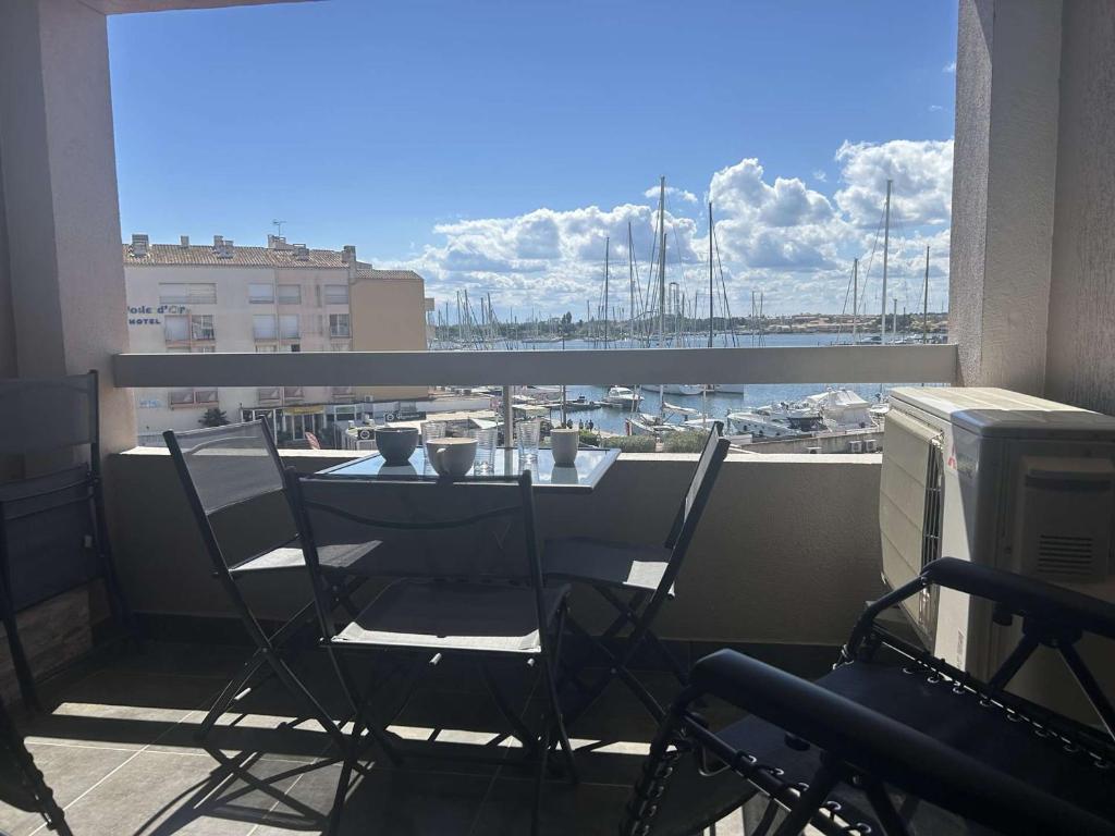d'une table et de chaises sur un balcon avec vue sur le port. dans l'établissement Appartement 2 pièces ensoleillé, vue sur port, proche plage - Cap d'Agde - FR-1-249-437, au Cap d'Agde
