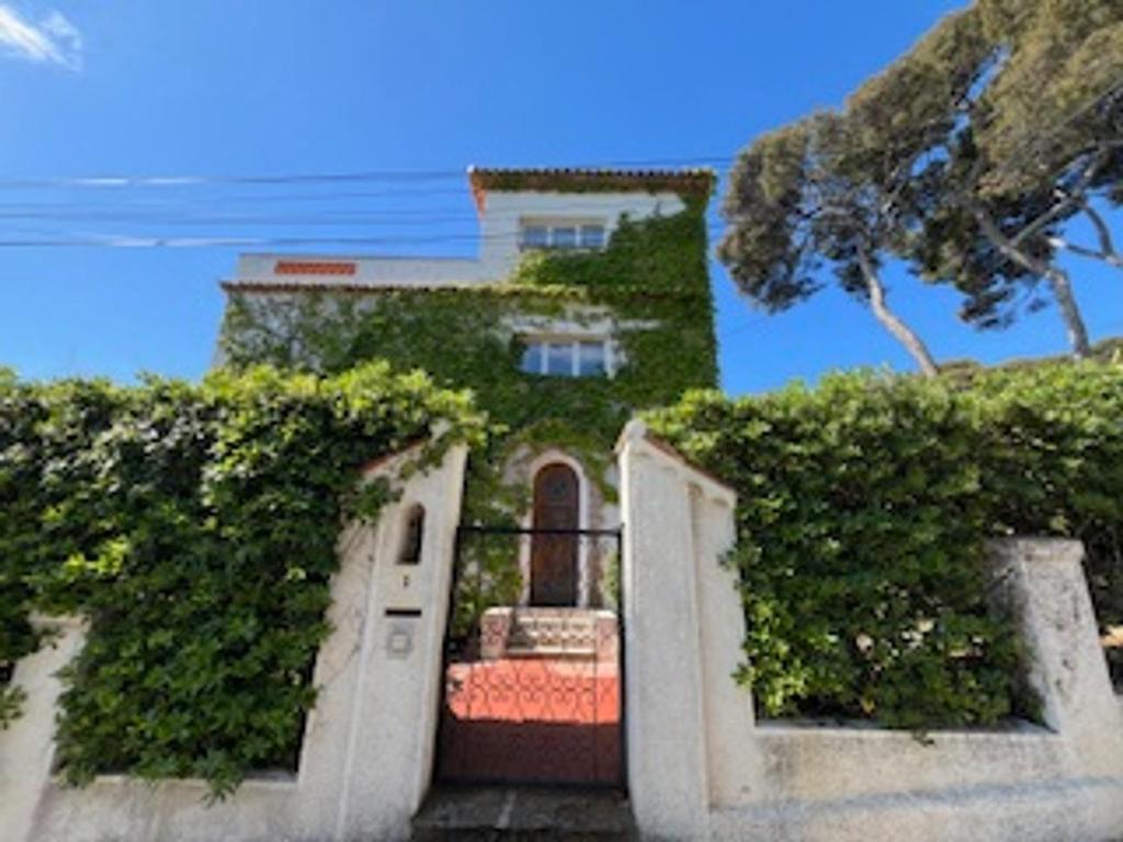 une maison avec une porte et du lierre qui y grandit dans l'établissement Villa exceptionnelle 8 couchages Cap d'Antibes en front de mer - FR-1-789-9, à Antibes