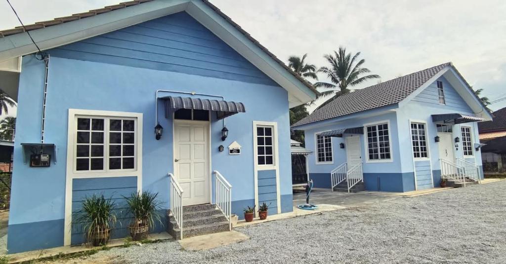 a blue house with a white door at Delima Guesthouse Type A in Wakaf Baharu
