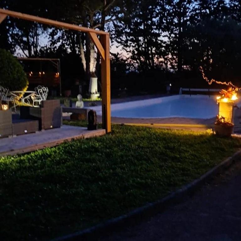 a view of a pool at night at Le nid du canal in Pezens