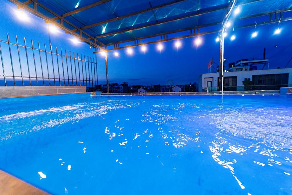 an indoor swimming pool at night with blue illumination at MELANTA HOTEL FLC SẦM SƠN in Sầm Sơn