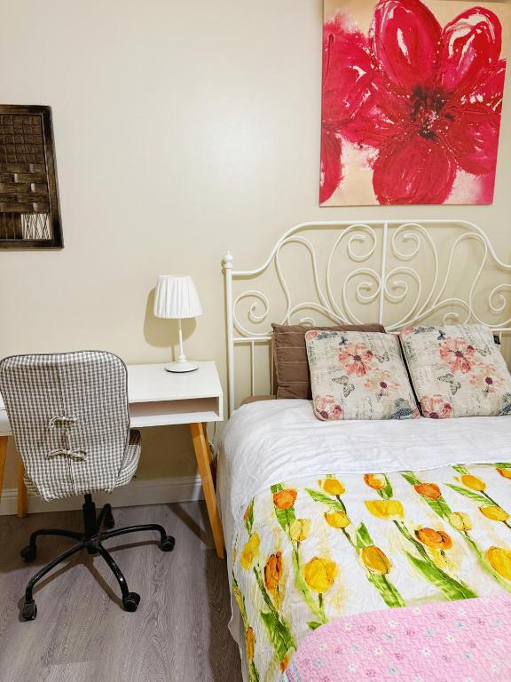 a bedroom with a bed and a desk with a chair at Gorgeous House&30 second Bus station Close C-Train& Free Parking in Calgary