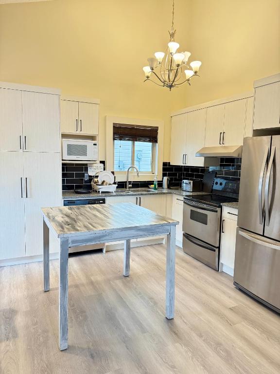 a kitchen with a table in the middle of it at Gorgeous House&30 second Bus station Close C-Train& Free Parking in Calgary