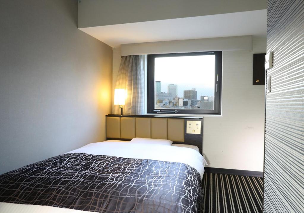 Postel nebo postele na pokoji v ubytování APA Hotel Kanda Jimbocho Ekihigashi