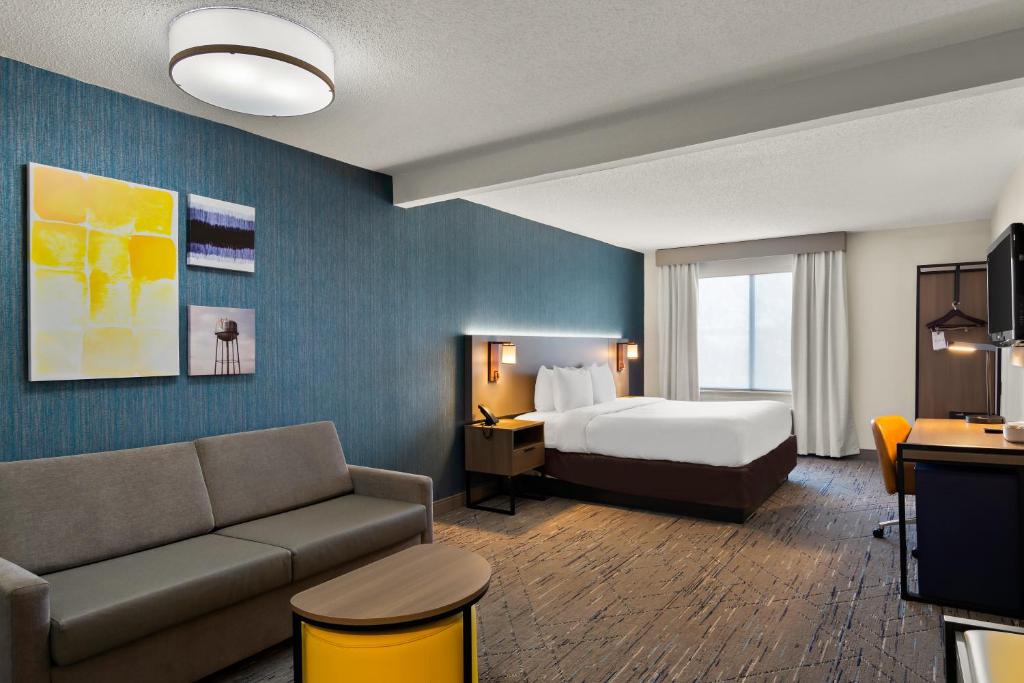 a hotel room with a bed and a couch at Comfort Inn & Suites Ashland - Richmond North in Ashland