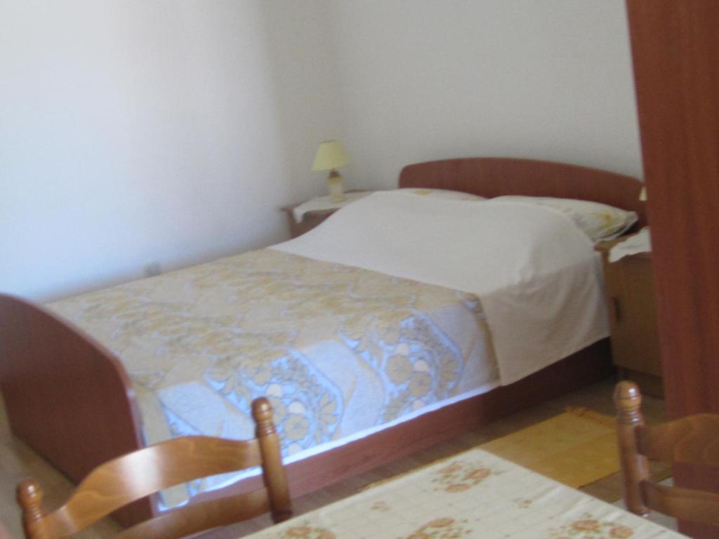 a bedroom with a bed and two chairs at Jagoda Apartments in Zaostrog