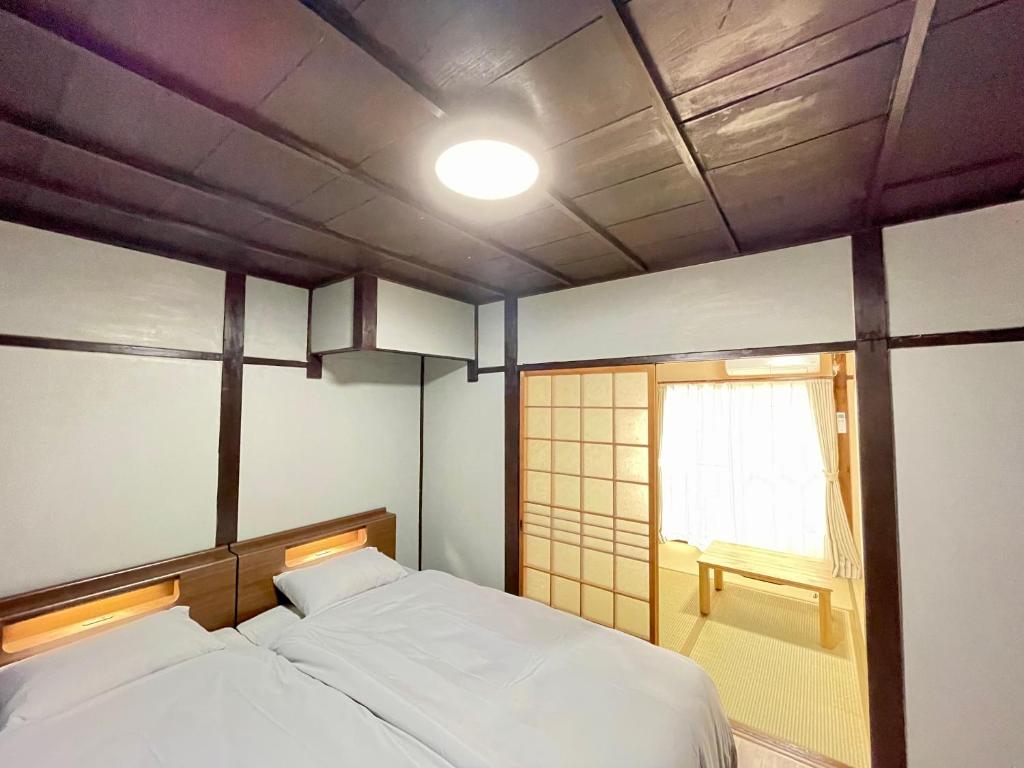 a small room with two beds and a window at サニーサイドホステル1号館 in Uji