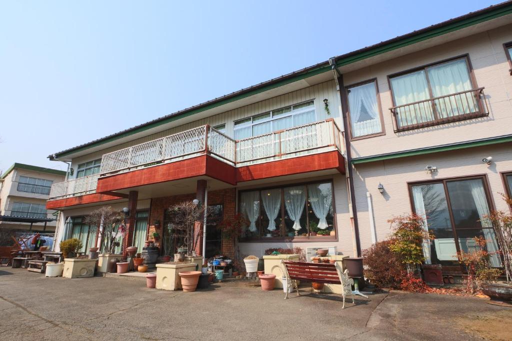 a building with a bench in front of it at Greenchair AMANO in Yamanakako