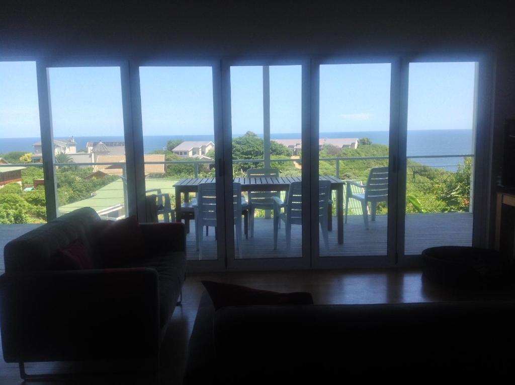 a living room with a table and a view of the ocean at By the Sea Vacation Home in Brenton-on-Sea