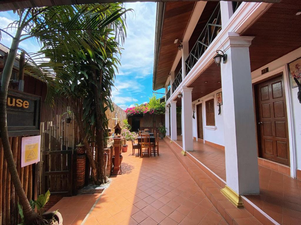 cortile di un edificio con tavoli e sedie di Mekong Chidlatda Villa a Luang Prabang