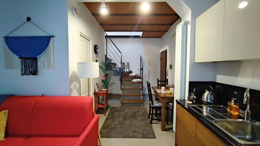 a living room with a red couch and a kitchen at La casa di E in Sesto Fiorentino