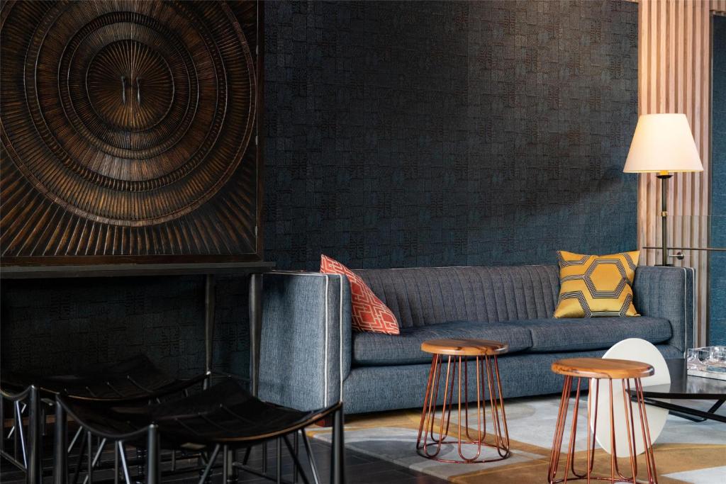 un soggiorno con divano blu e sgabelli di Hyatt Centric San Isidro Lima a Lima