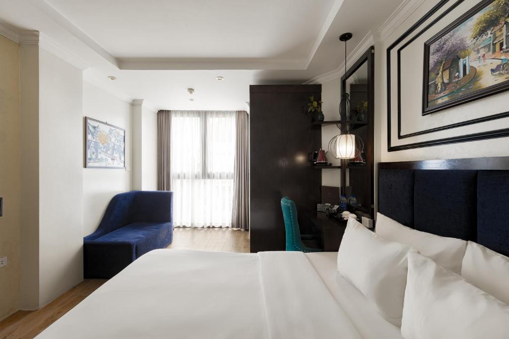 a bedroom with a large white bed and a blue chair at Bella Rosa Trendy Hotel & Spa in Hanoi