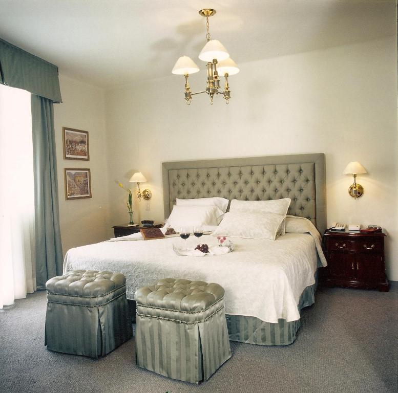 - une chambre avec un grand lit et 2 ottomanes dans l'établissement Casa Corp Boutique Suites in Condesa, à Mexico