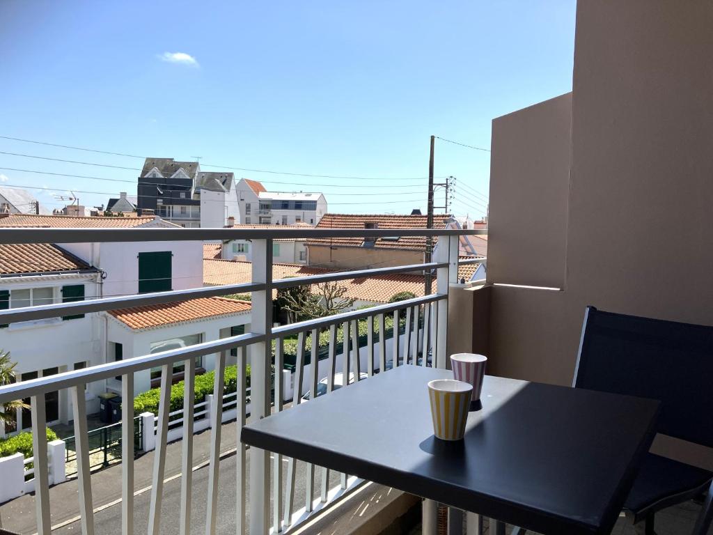 une table sur un balcon avec vue sur une ville dans l'établissement Au gré du vent - Saint Gilles Croix de Vie, à Saint-Gilles-Croix-de-Vie
