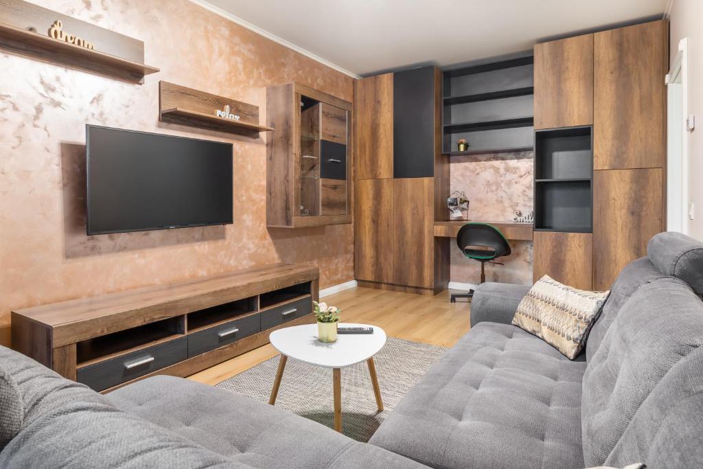 a living room with a couch and a tv at Quebec Flat in Oradea