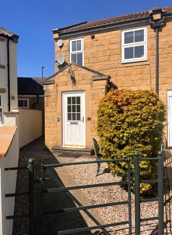 a brick house with a white door at Castle Cottage in Harrogate
