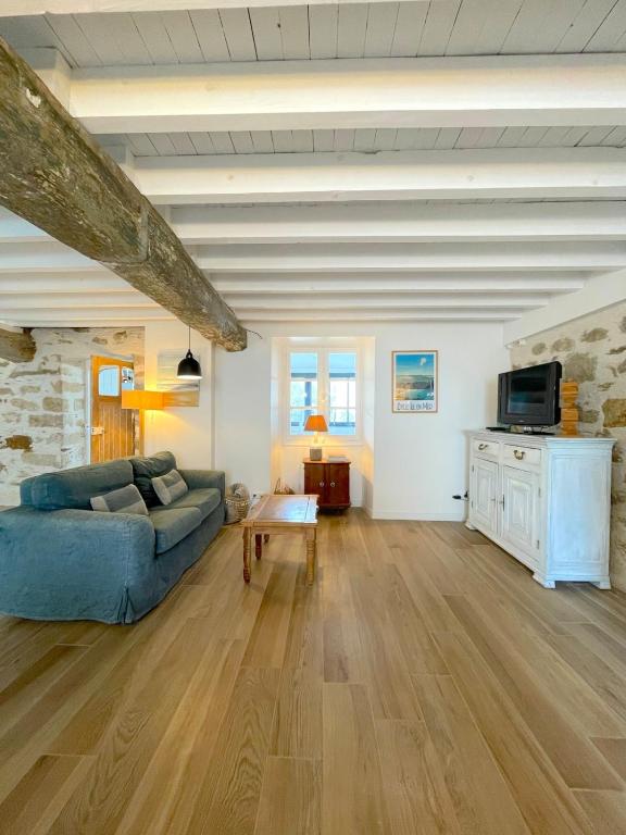 un salon avec un canapé bleu et une télévision dans l'établissement Maison bord de mer ・La côtière・, à Piriac-sur-Mer
