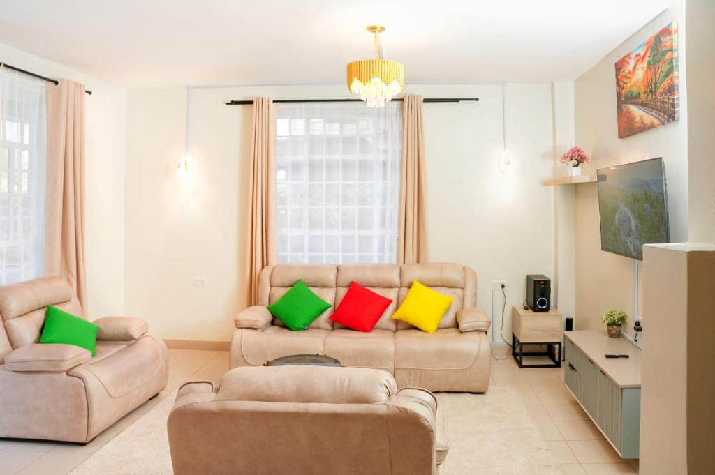 a living room with two chairs and a couch with colorful pillows at Shalom Haven in Naivasha