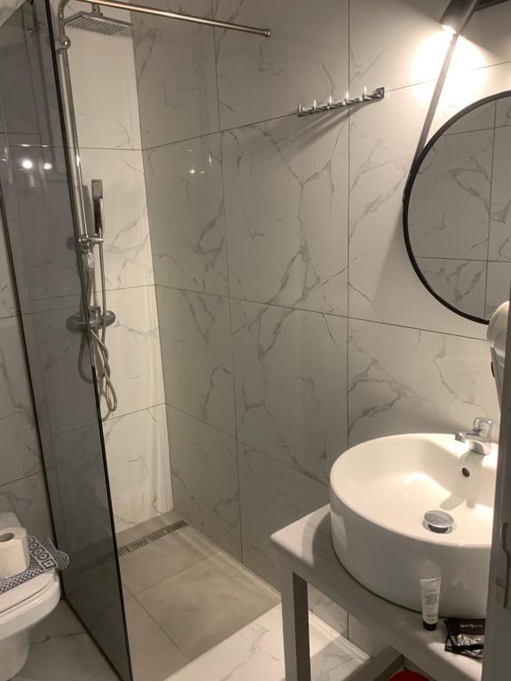 W łazience znajduje się prysznic, umywalka i lustro. w obiekcie Hotel Parthenon Rodos city w mieście Rodos