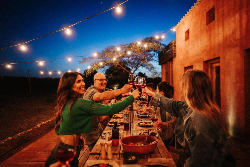 a group of people holding glasses of wine at a table at eumelia organic agrotourism farm in Goúvai