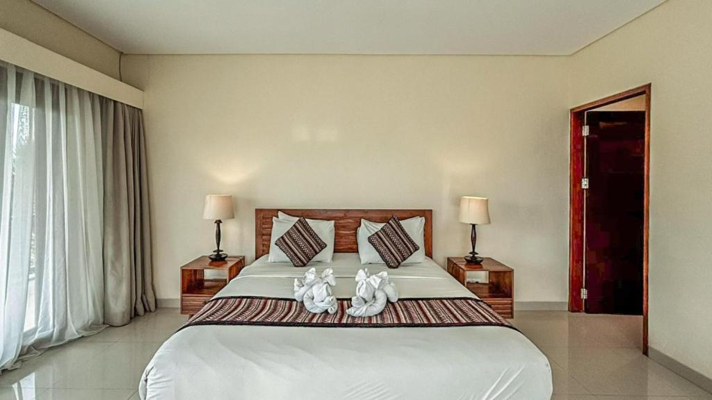 Postel nebo postele na pokoji v ubytování DLobong Suites Ubud