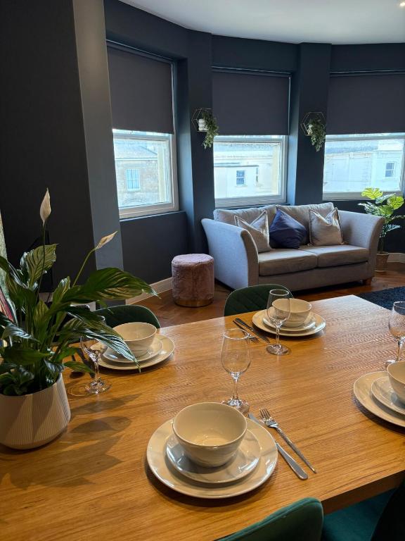 Hotel Cosy flat with sea view, a dining room table with plates and wine glasses on it at Cosy flat with sea view in Brighton & Hove