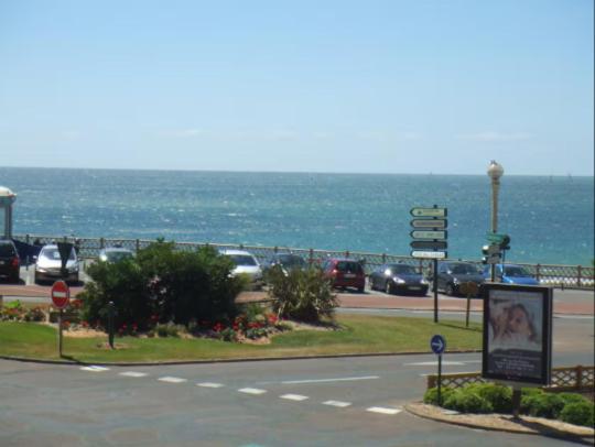 une route avec des voitures garées à côté de l'océan dans l'établissement Les Mouettes, à Les Sables-dʼOlonne