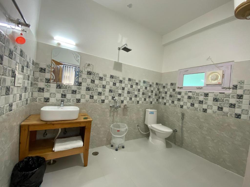 a bathroom with a sink and a toilet at Diya Mountain House Tirthan in Banjār