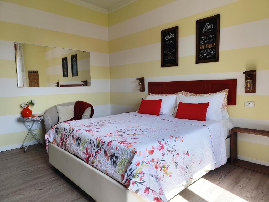 a bedroom with a large bed with red pillows at La Bicicletta Rooms in Cremona