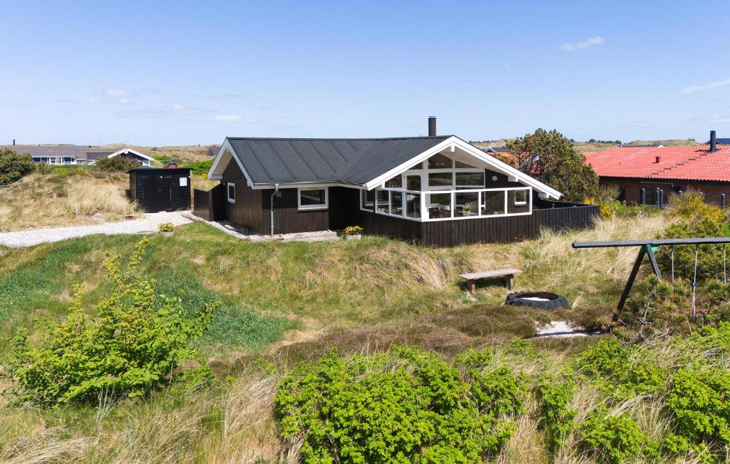 a house sitting on top of a grassy hill at Holiday Home Bjerregårdsvej Hvide Sande in Bjerregård