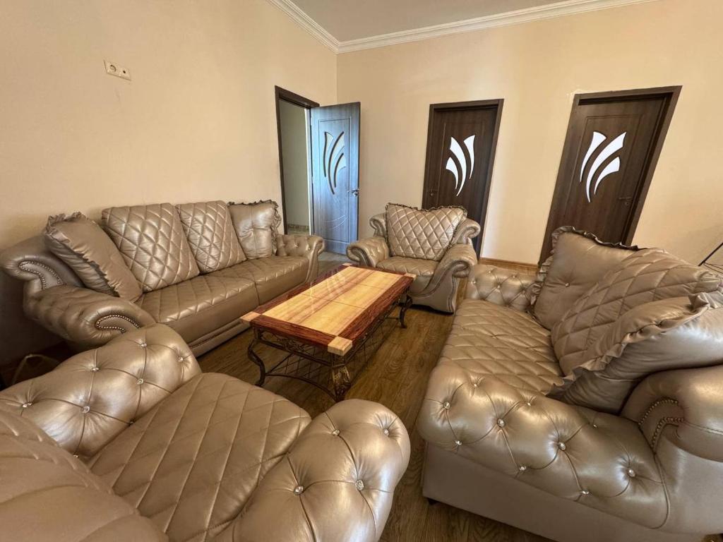 a living room with leather couches and a coffee table at Hello Batumi Apartment in Batumi