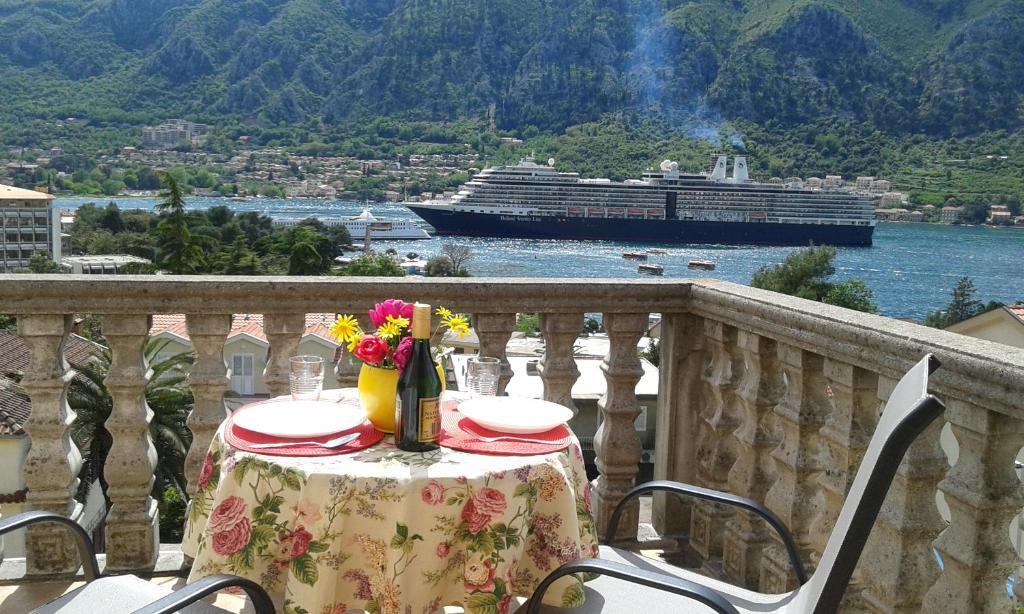 a table on a balcony with a cruise ship in the water at Apartment Ivan in Kotor