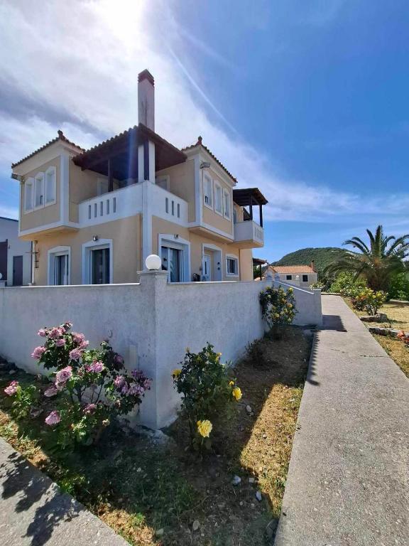 a large white house with flowers in front of it at Panorama Villa in Plátanos