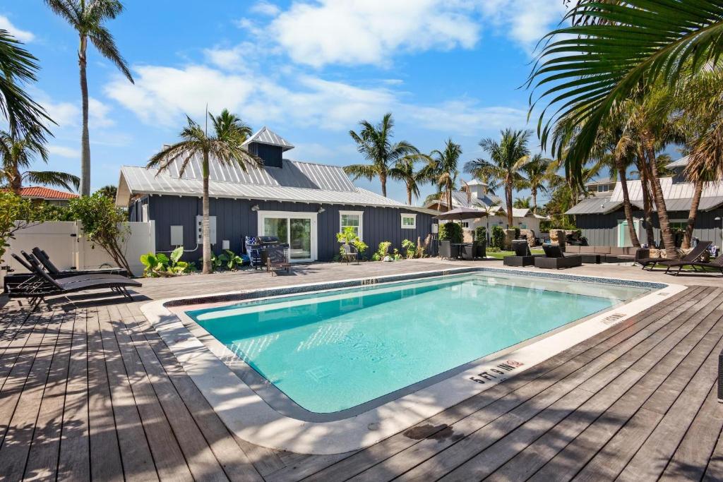 a swimming pool in front of a house with palm trees at Villa #3 Seahorse in Holmes Beach