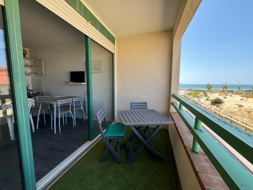 un balcon avec une table et des chaises et une vue sur la plage dans l'établissement Cap Océan, à Mimizan