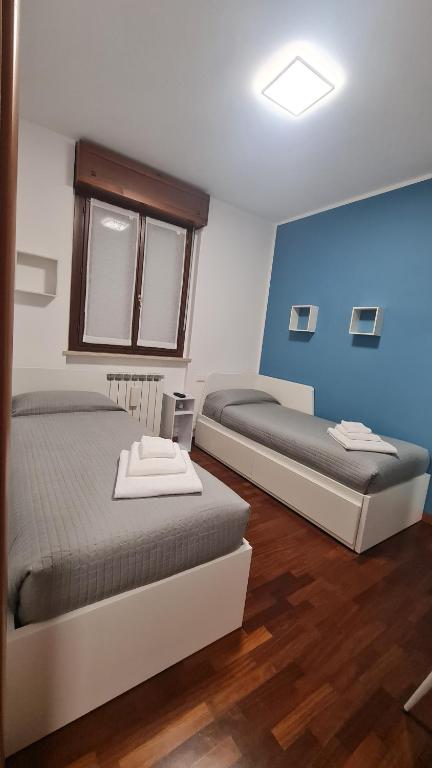 a bedroom with two beds and a blue wall at Casa Gavazzeni Il Sogno in Bergamo
