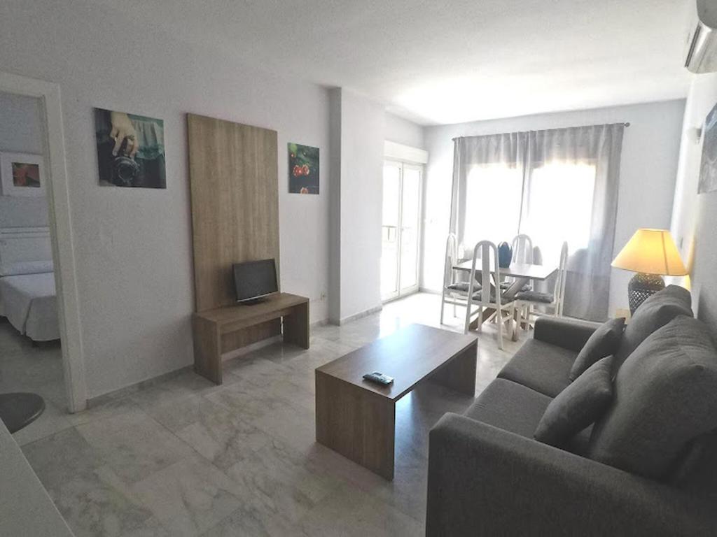 salon z kanapą i stołem w obiekcie Pleasant apartment in Benalmadena near Playa Beach w mieście Benalmádena