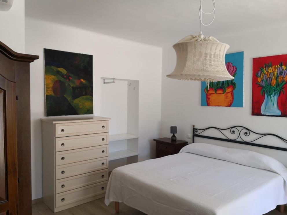 een slaapkamer met een bed, een dressoir en een lamp bij Mololocale in centro a Marcelli in Marcelli