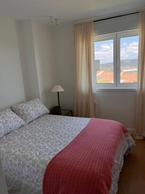 ein Schlafzimmer mit einem Bett und einem großen Fenster in der Unterkunft #OcéanoAtlántico in San Vicente do Mar