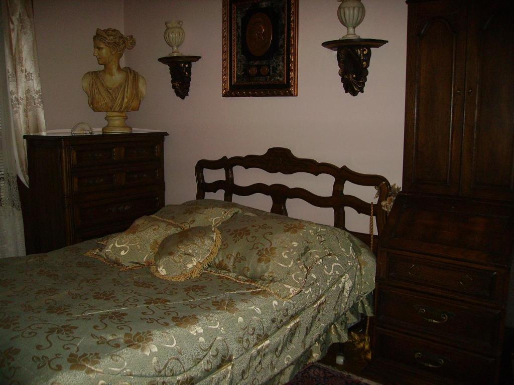 a bedroom with a bed and a dresser with a bust on it at Victoriański 15 & Antyczny 16 in Kazimierz Dolny