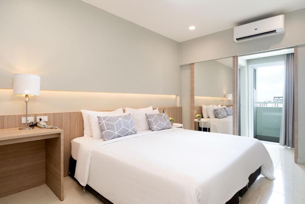 a bedroom with a large white bed and a window at Synsiri Lat Phrao 83 in Ban Zong Katiam