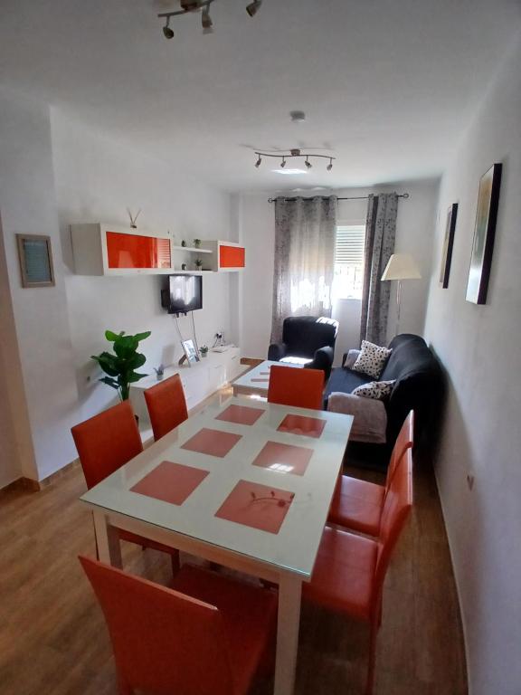 a dining room and living room with a table and chairs at Bonito piso de 2 habitaciones in Híjar